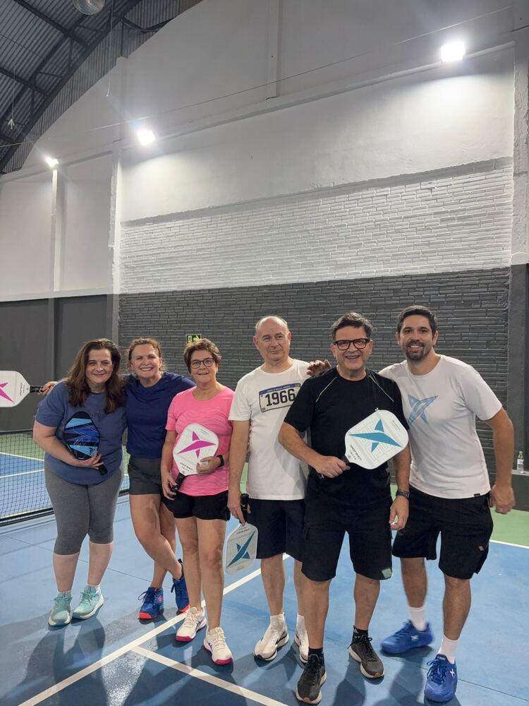Turma de alunos posando com paddles na quadra