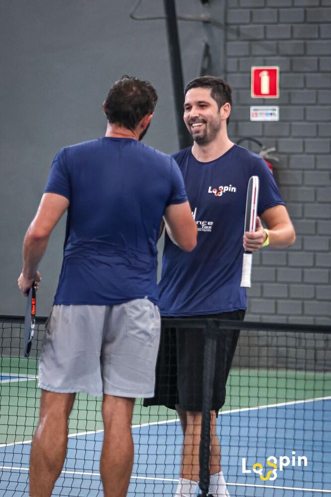 Lucas cumprimentando adversário na rede após partida